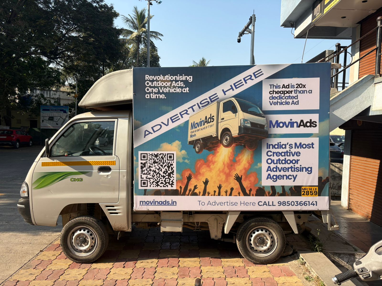 Four-wheeler tempo carrying a MovinAds advertising panel